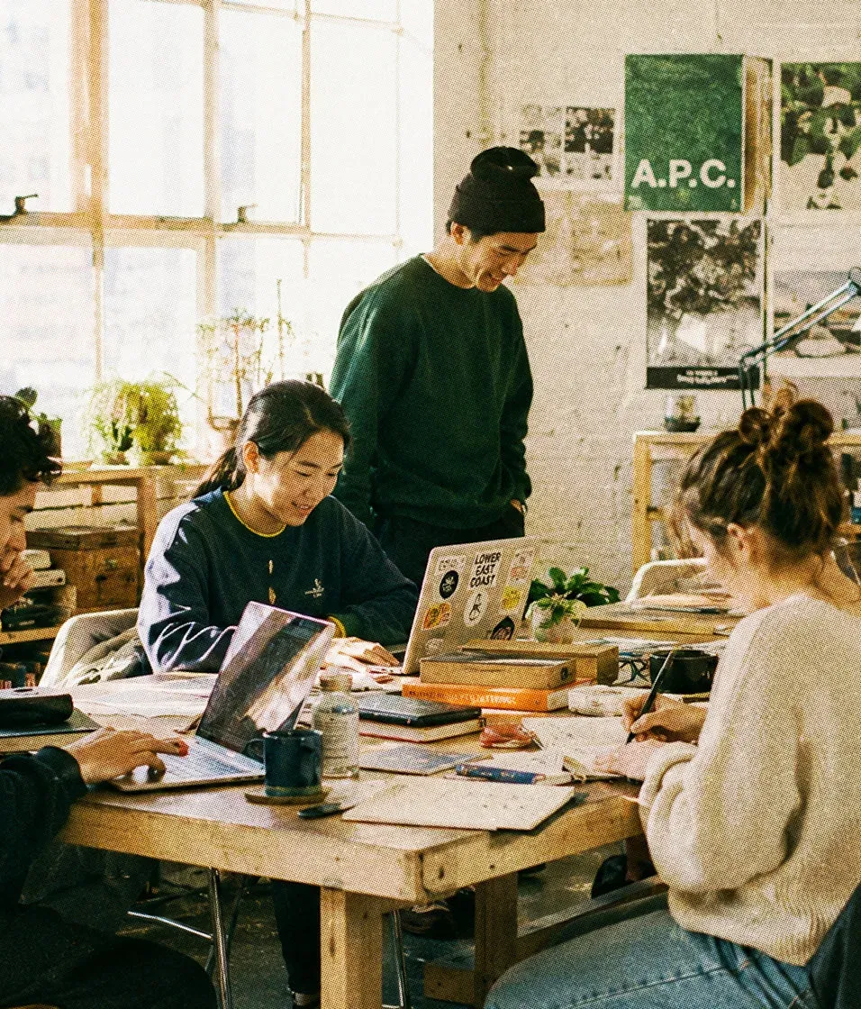 A team collaborating around a table, with a Base44-built task-status dashboard.