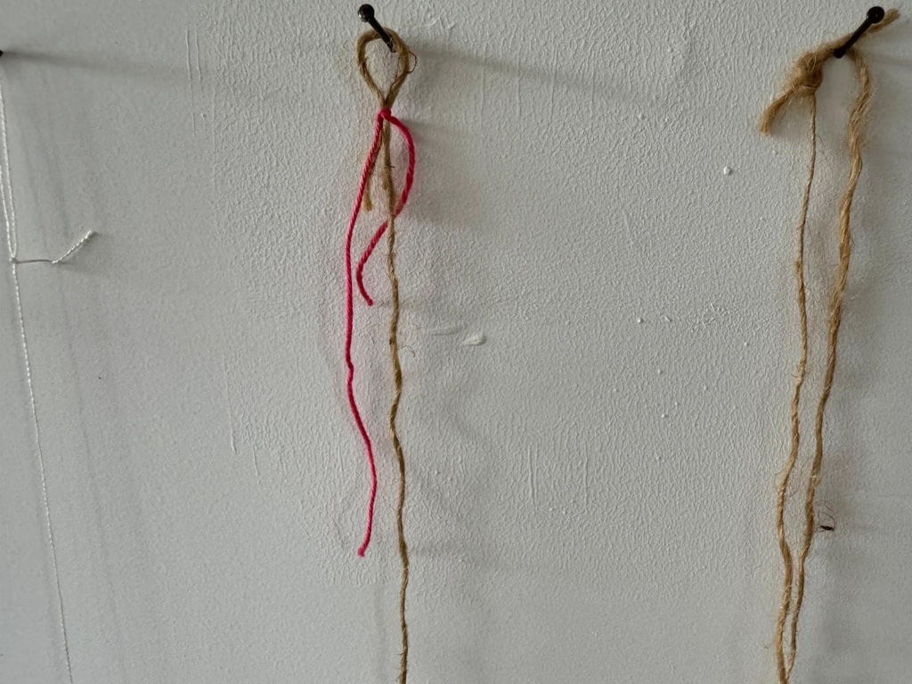 Twine and thread hanging from wall hooks | חבל וחוט תלויים מווי קיר