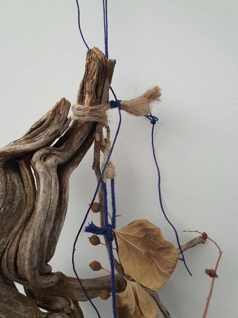 Driftwood with blue thread and dried golden leaf | עץ סחוף עם חוט כחול ועלה מוזהב מיובש