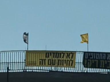 NOW IS NOW banner with faces | שלט עכשיו זה עכשיו עם פרצופים