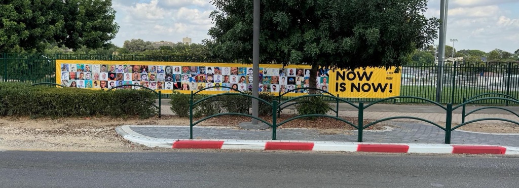 Yellow flags and protest sign in desert landscape | דגלים צהובים ושלט מחאה בנוף מדברי