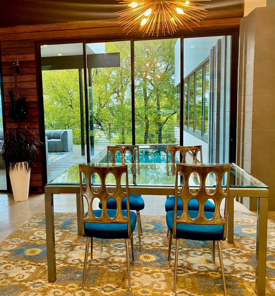 Elegant dining area with designer gold chairs and pool view