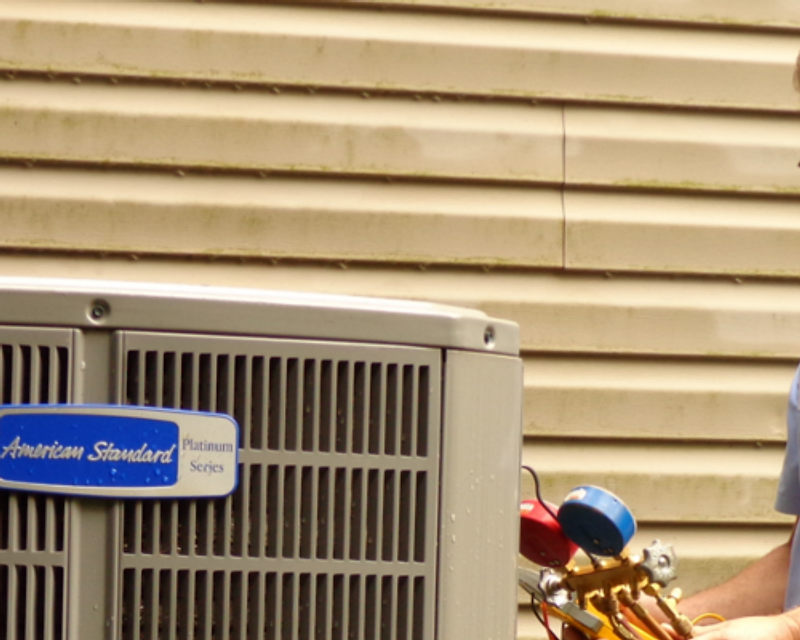 Floyd's Heating & Air technician servicing an American Standard HVAC unit in Spartanburg, SC