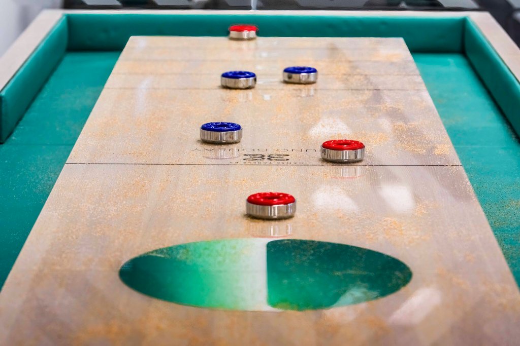 Handmade shuffleboard table handcrafted from solid hardwood in a luxury interior
