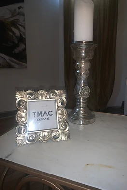 TMAC Skincare frame and candle on a marble table