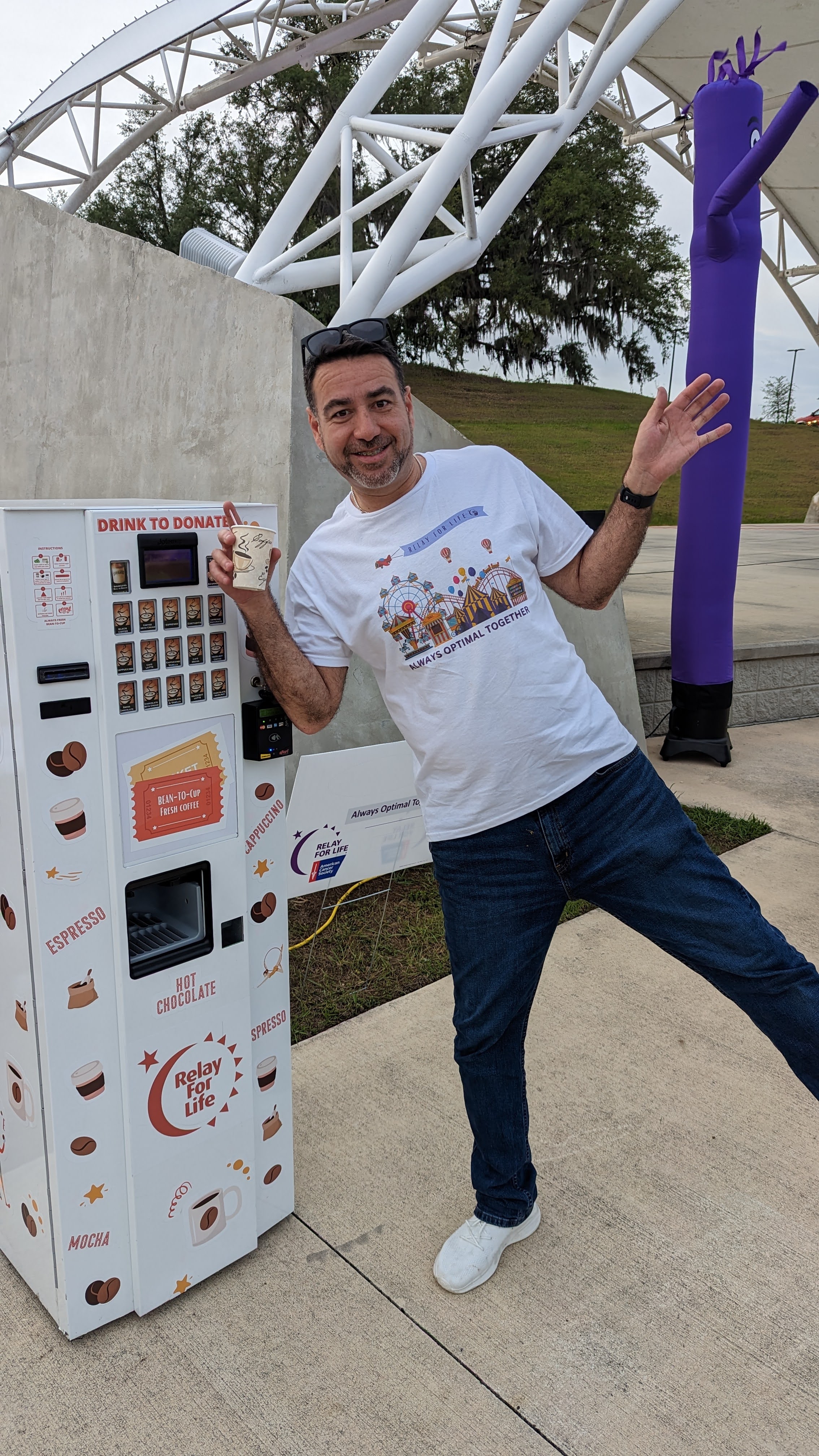 Teddy Sanchez beside the Relay for Life coffee and donation machine at a community event