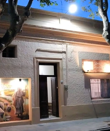 The church building in downtown Durazno at dusk, its Good Shepherd mural glowing