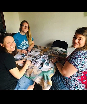 Co-laborers preparing gospel literature around a table in Durazno