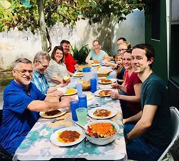 Church family and friends sharing an asado meal under the grapevines