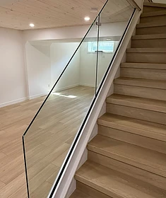Modern frameless glass stair railing in a Winnipeg home with open sightlines