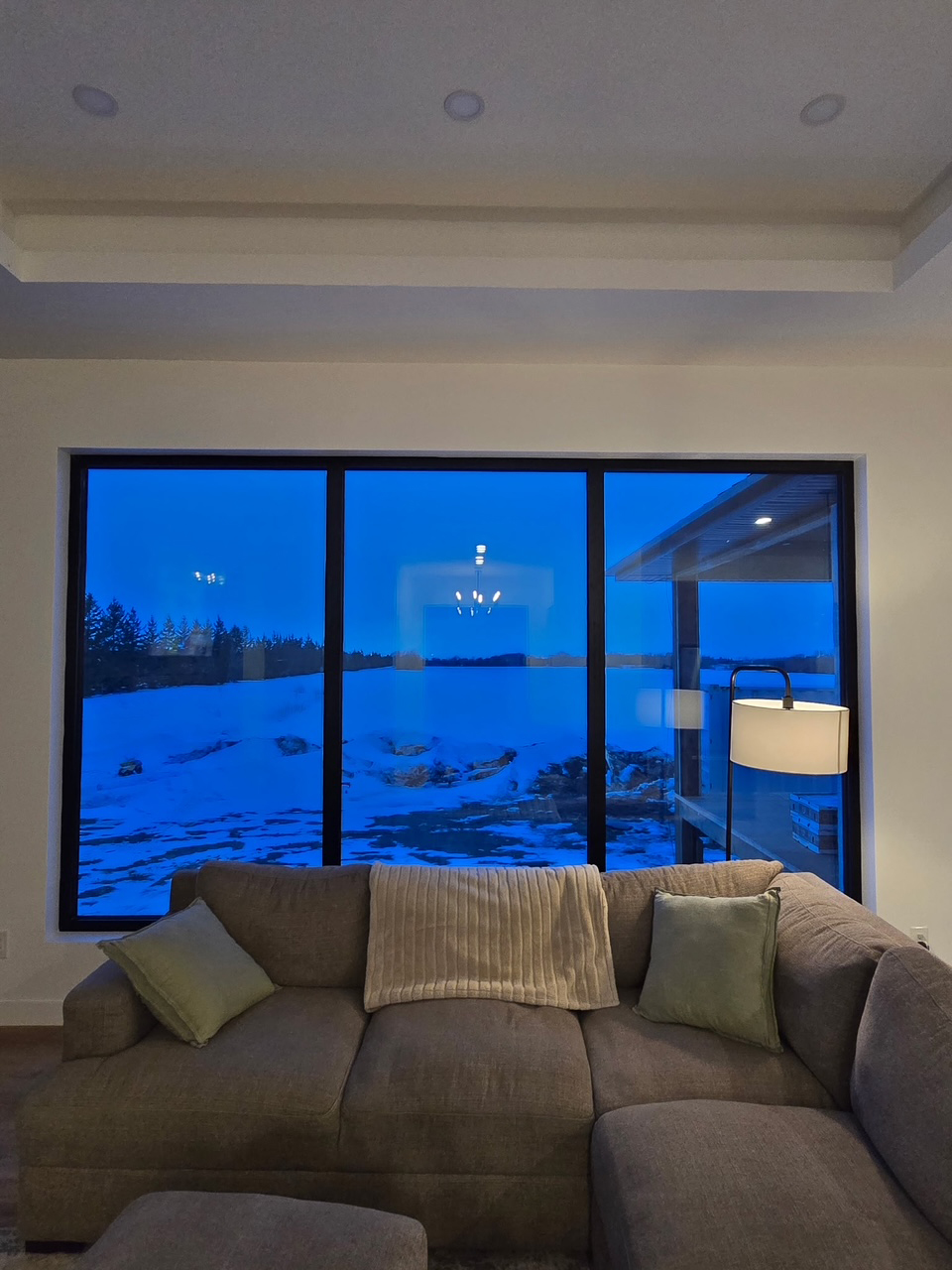 Large architectural glass windows framing a winter view in a custom Winnipeg home