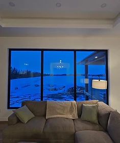 Large architectural glass windows framing a winter view in a custom Winnipeg home