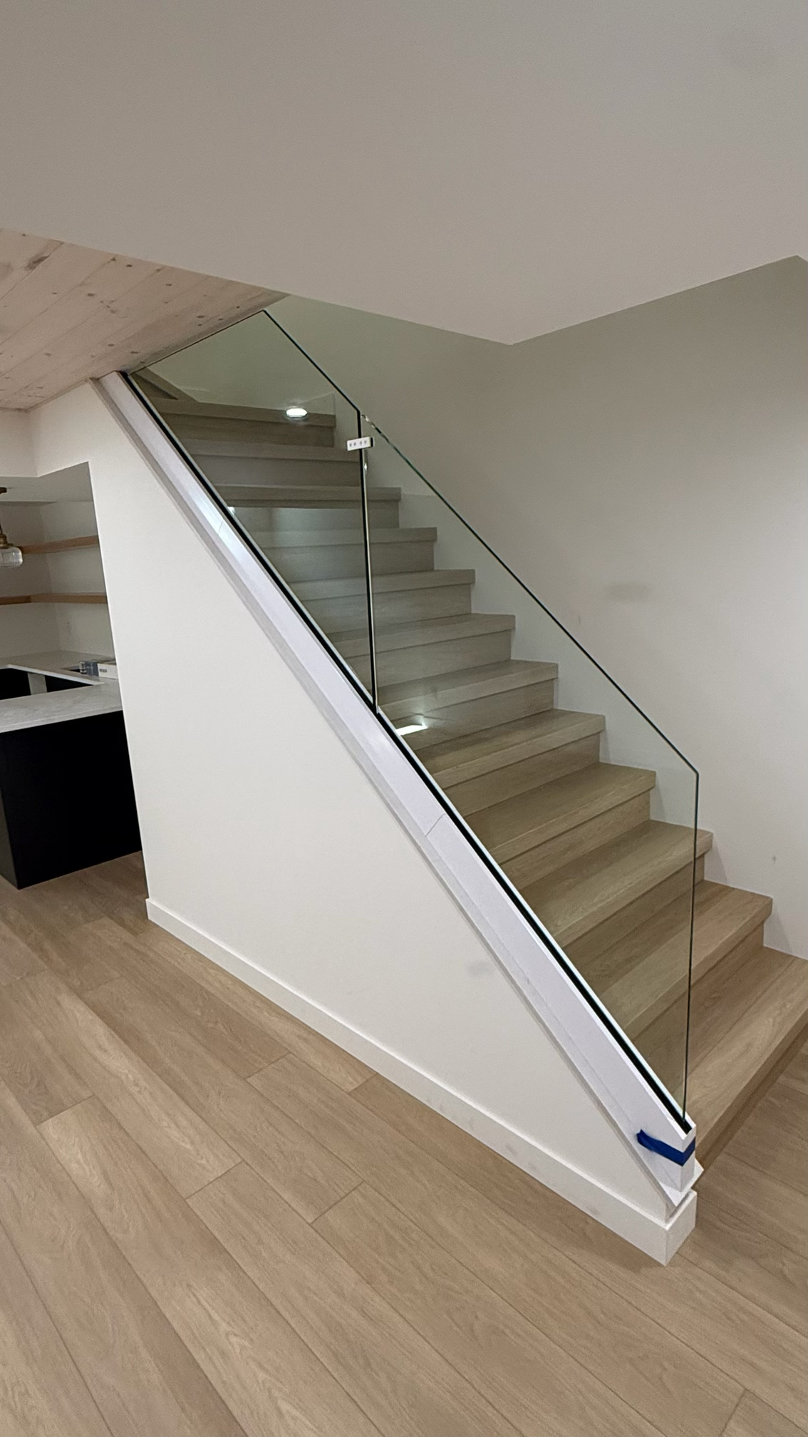 Frameless glass balustrade along an oak staircase showing precise alignment