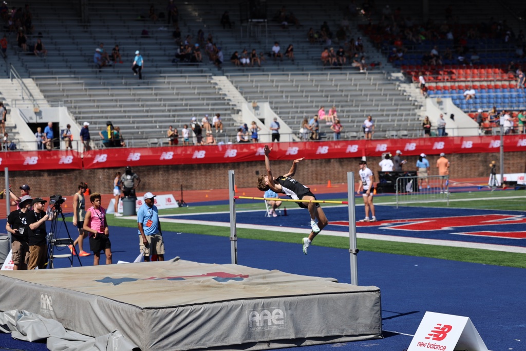 Wade Williams clearing a high jump bar at a stadium