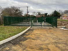 Green vertical metal rail fence