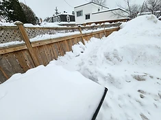 Storm-damaged fence blown down in winter