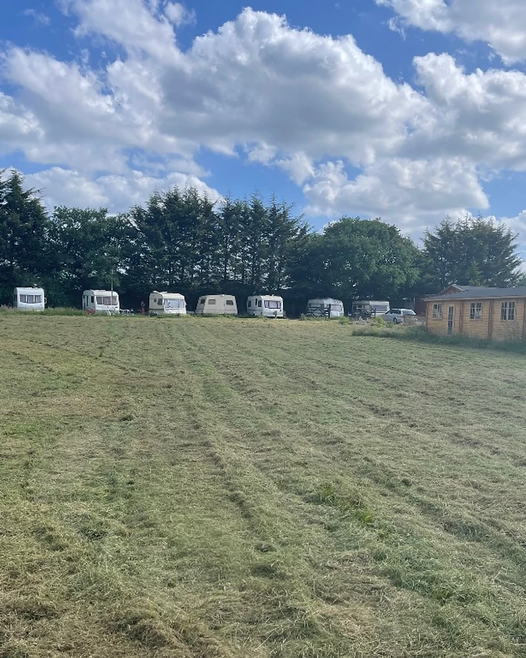 The main field at Willows with caravans and the lodge