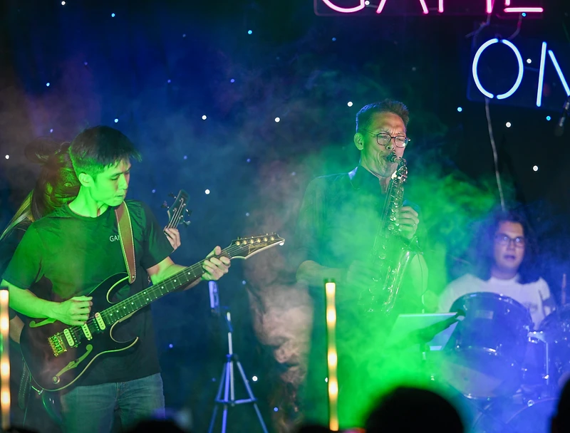 GAME ON guitarist and saxophonist playing in green haze