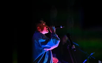 Vocalist singing in dramatic stage light