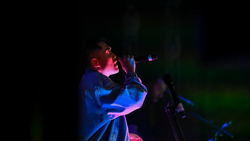 GAME ON vocalist singing in dramatic stage light