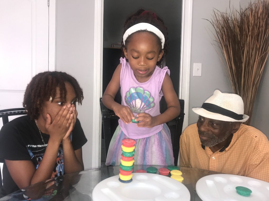 Family playing Stack the Rainbow