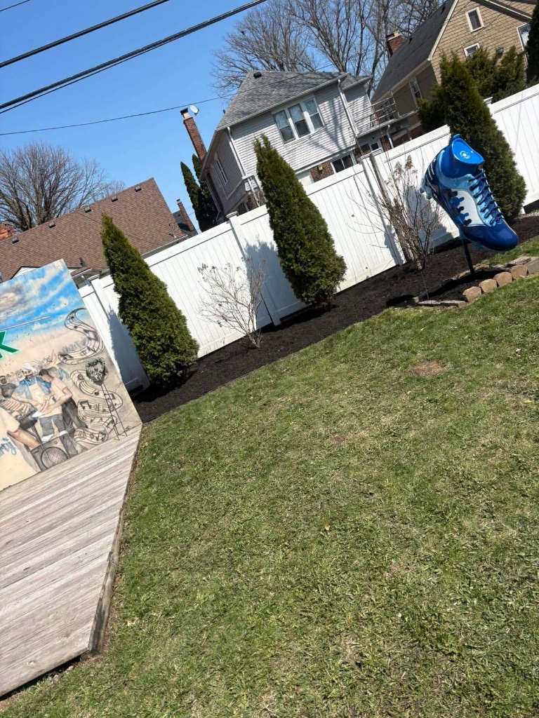 Fresh mulch beds along fence line in Grosse Pointe Park