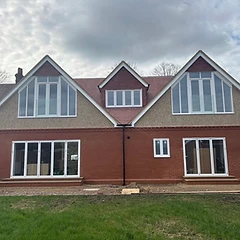 Rear of a house with new gable windows and white bi-fold doors fitted by JC Carpentry