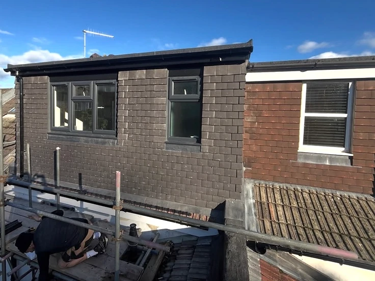 Tile-hung rear dormer with grey windows and lead flashings on a terraced house