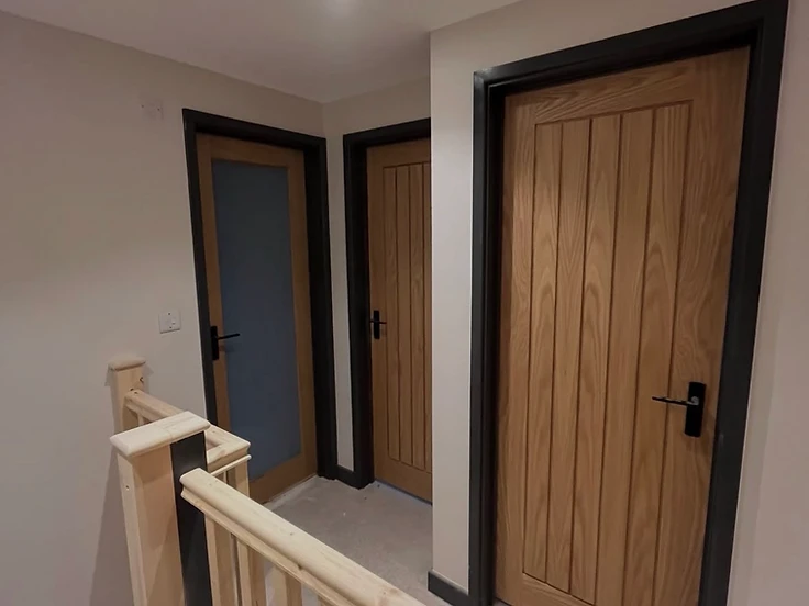 Solid oak internal doors with dark architrave and a new pine staircase