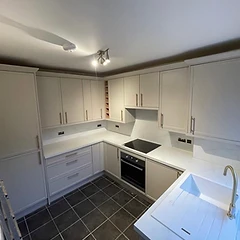 Cream shaker kitchen with marble-effect worktop and brass tap