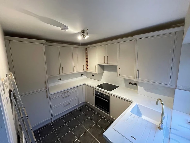 Cream shaker kitchen with marble-effect worktop and brass tap