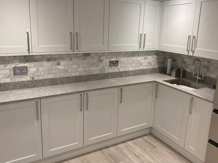 Light grey kitchen with marble brick tiles and granite-effect worktop
