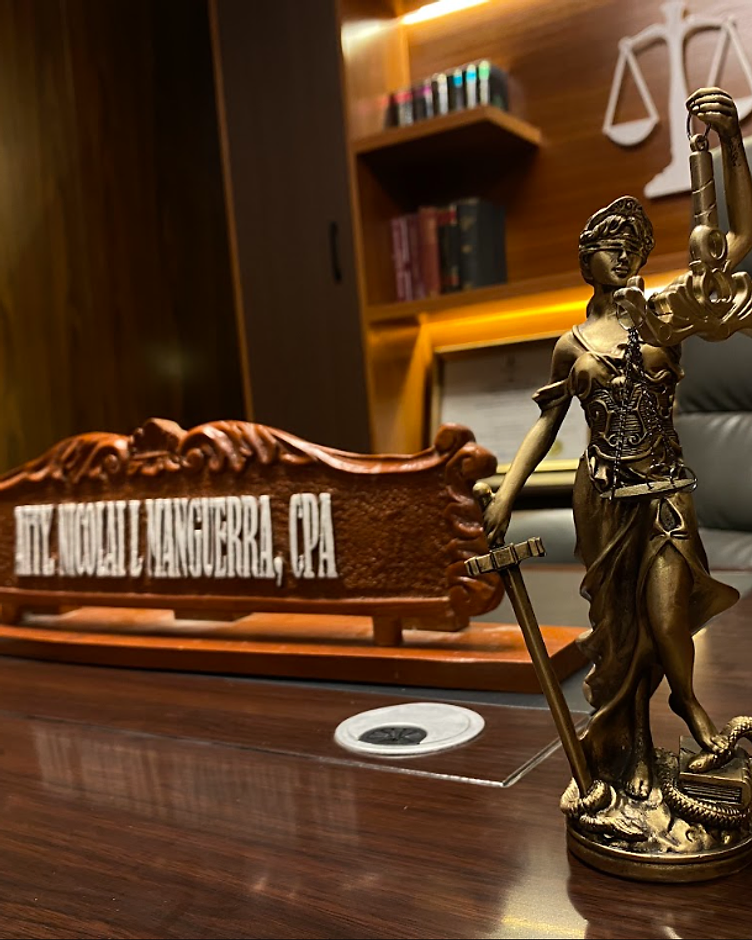Lady Justice statuette and nameplate reading Atty. Nicolai L. Manguerra, CPA — conveying authority and professionalism
