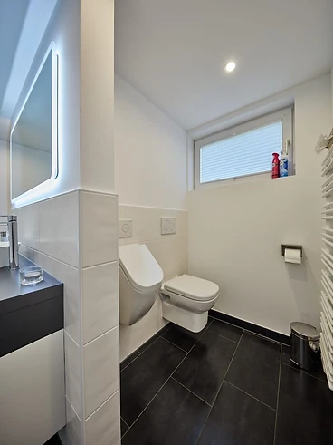 Fertiges Gäste-WC mit heller Fliesenwand