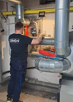 Simon-Mitarbeiter bei der Arbeit an einer großen Heizungsanlage