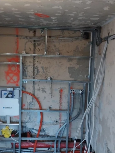 Rohinstallation mit Leitungen und Spülkasten hinter der Wand
