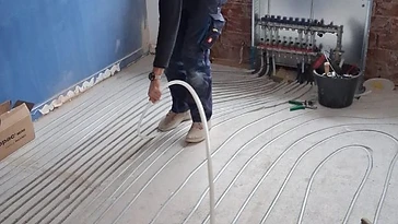Heizrohre werden in gefräste Kanäle im vorhandenen Estrich verlegt