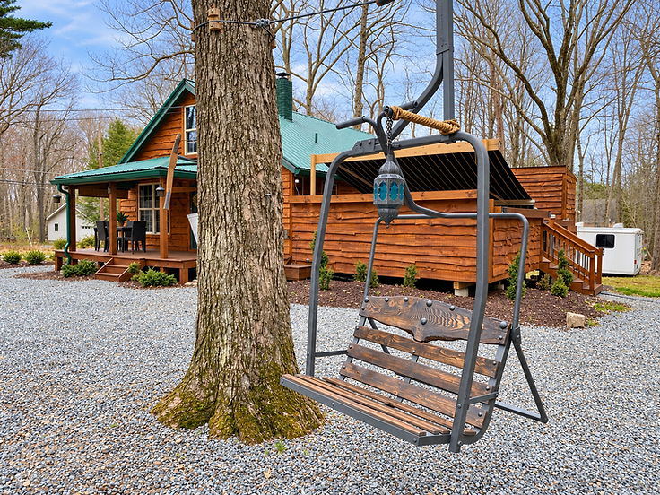 Repurposed ski-lift chair swing hanging from a tree in the front yard of the Pocono cottage