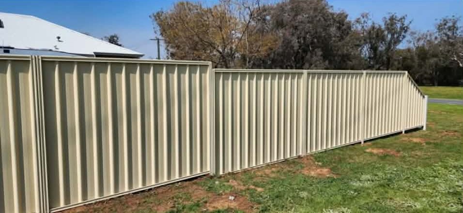 Long cream coloured aluminium vertical slat boundary fencing along a property perimeter