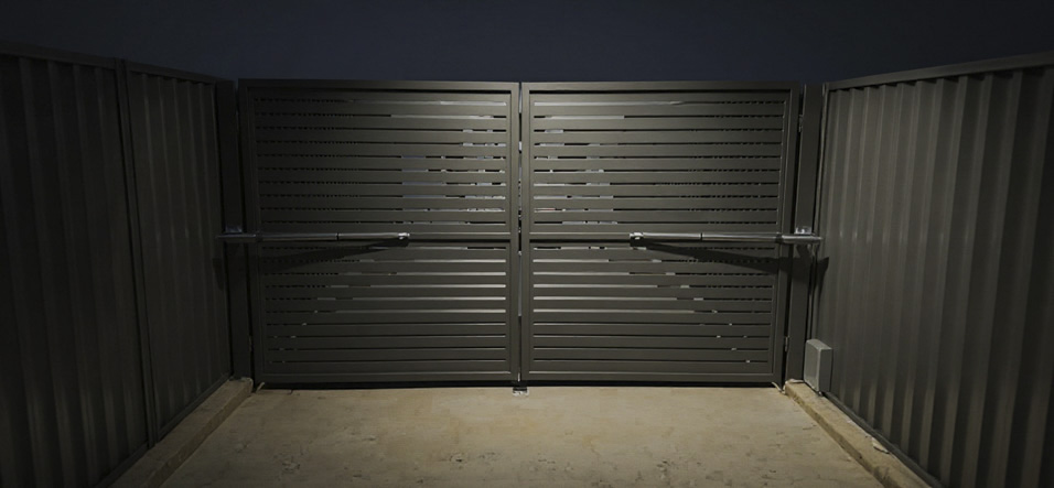 Automated charcoal aluminium double swing gate with horizontal slats at a modern residence