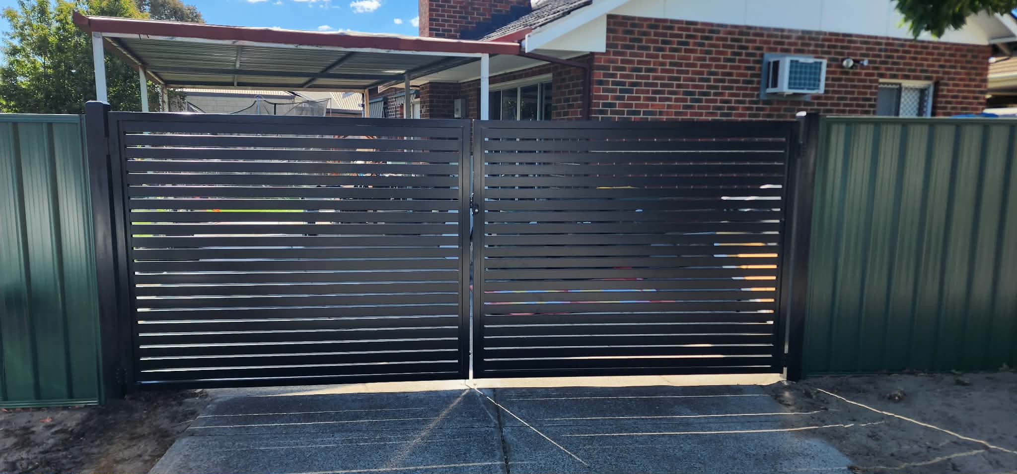 Large black aluminium double driveway swing gate with horizontal slat design