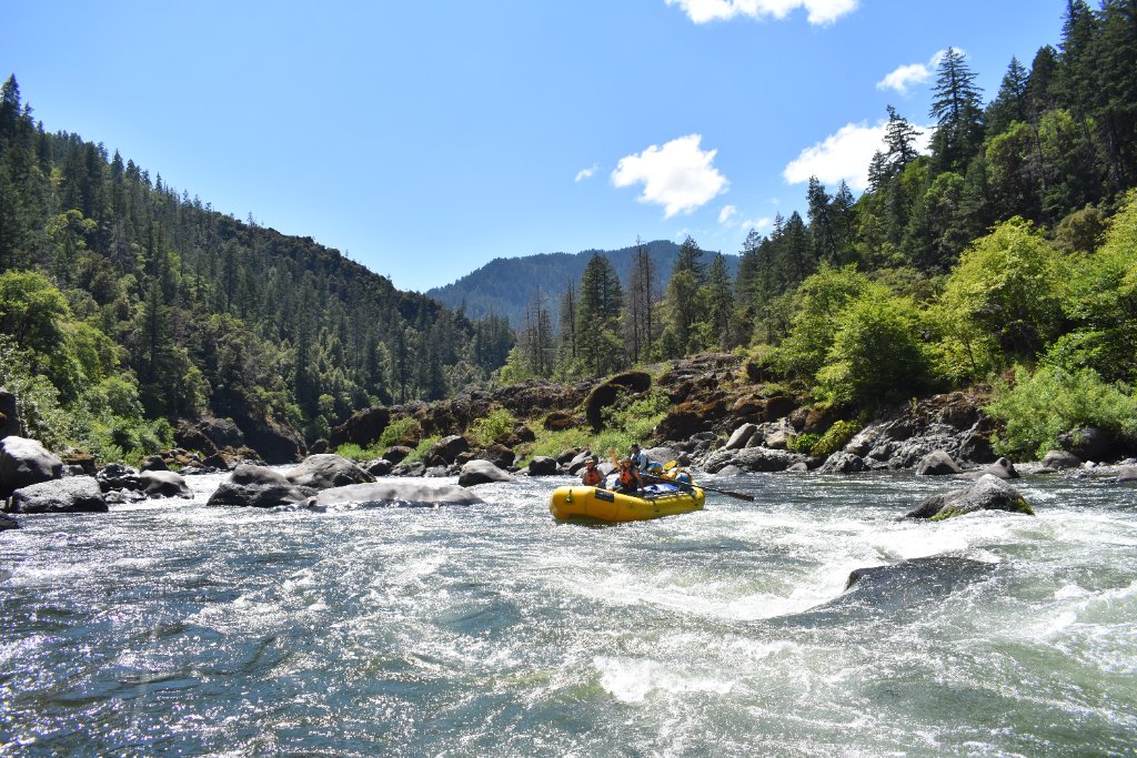 Yellow raft navigating through stunning Rogue River canyon