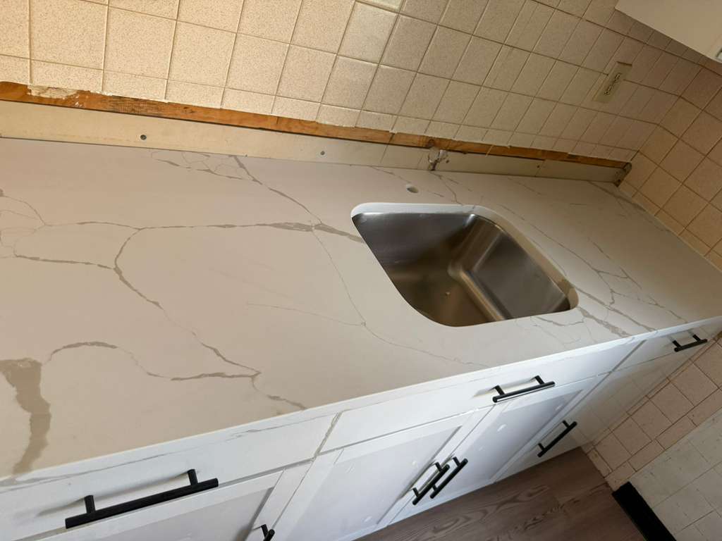 Cream quartz countertop L-shaped kitchen installation