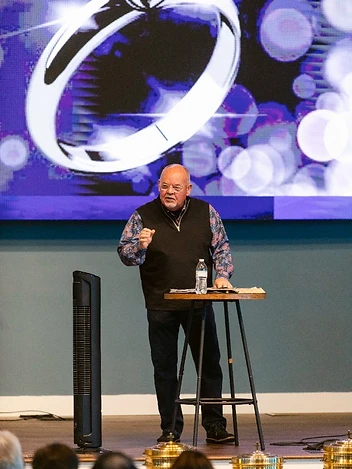 The pastor preaches from the stage during a Sunday service