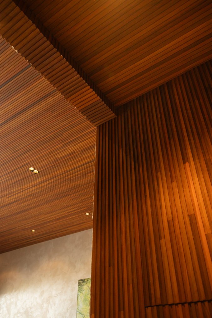 Interior luxuoso com forro de madeira e parede de pedra