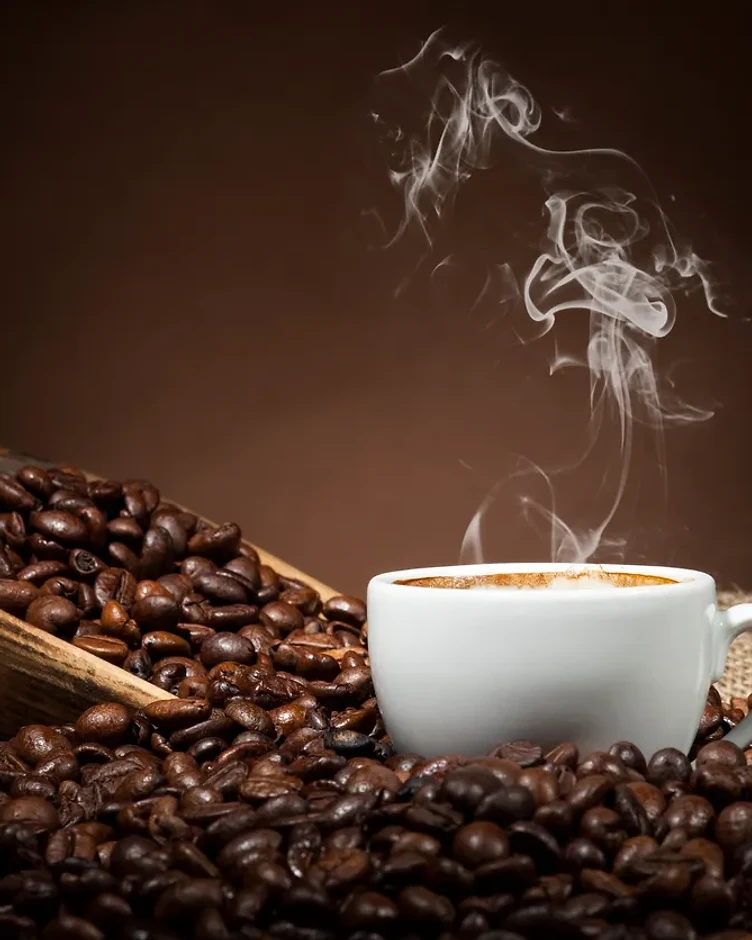 A cup of black coffee on roasted beans