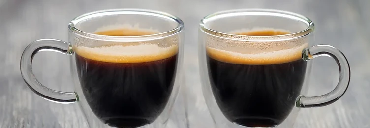 Two espresso cups on a wooden surface