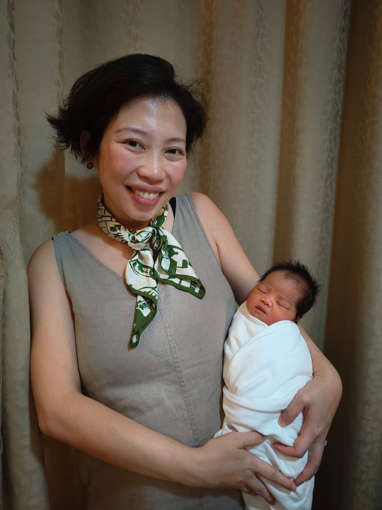 Dr Shilla holding a newborn baby, supporting a family through another pregnancy