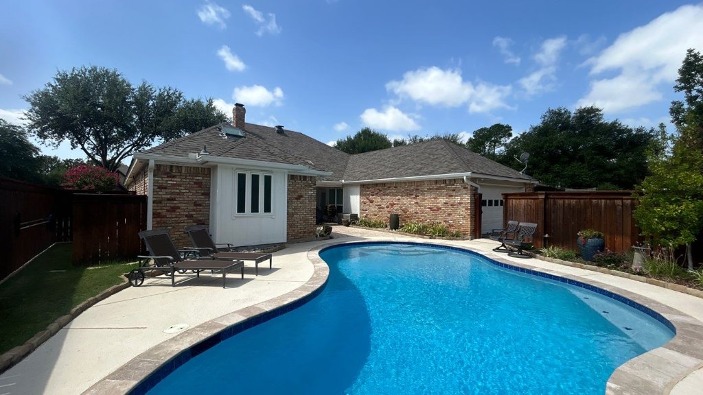 Brick home in North Texas with a completed new roof and backyard pool, installed by Becker Roofing