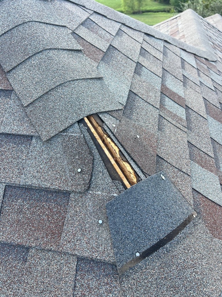 Missing ridge cap shingles caused by straight-line winds on a North Texas roof